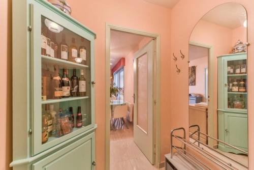 - un couloir avec une porte menant à une chambre avec des bouteilles de vin dans l'établissement Apartment Boulouris, à Saint-Raphaël