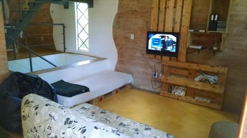 un salon avec un canapé et une télévision dans l'établissement Frio em Monte Verde, à Monte Verde