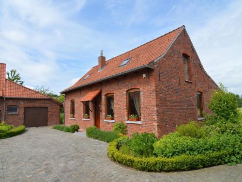 a brick house with a driveway in front of it at Cozy Holiday Home in Ploegsteert with a Garden in Le Bizet
