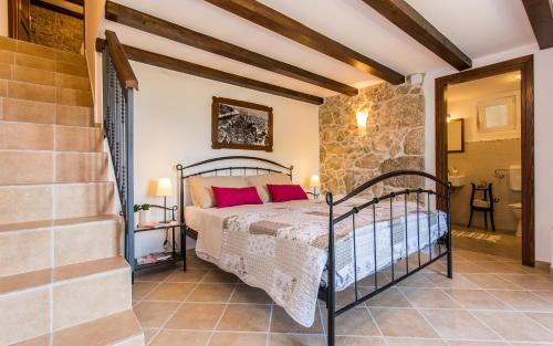a bedroom with a bed and a stone wall at Apartman Bonaca in Vrbnik