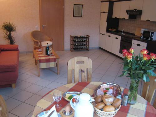 Sch ne Wohnung in der Moselregion في Kinheim: مطبخ وغرفة معيشة مع طاولة عليها طعام