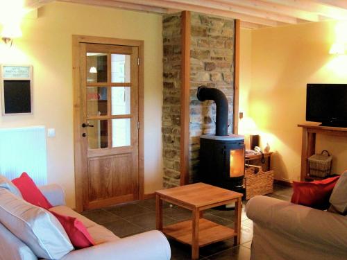 a living room with a stone fireplace and a couch at Fort like Holiday Home in Sart Bertrix a drive away from Luxembourg in Sart