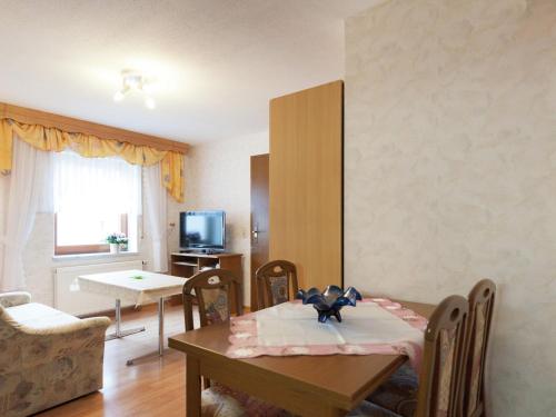 a living room with a table and a dining room at Beautiful Apartment in P hla Saxony near Ski Area in Pöhla