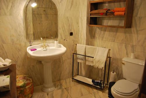 uma casa de banho com um lavatório, um WC e um espelho. em Casa Rural La Cuadraá em Linares de Riofrío