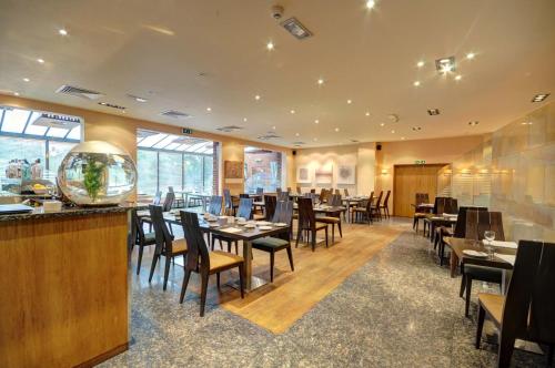 een restaurant met tafels en stoelen en een bar bij Cabarfeidh Hotel in Stornoway