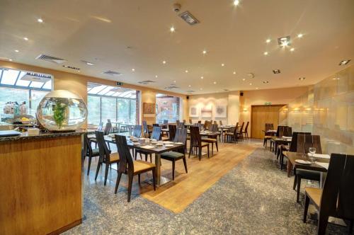 um restaurante com mesas e cadeiras e um bar em Cabarfeidh Hotel em Stornoway