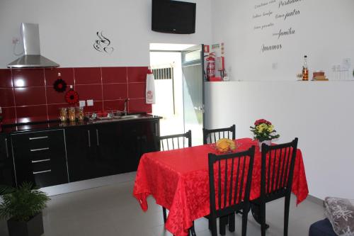 a kitchen with a table with a red table cloth at Casa do Rio - Penacova in Raiva