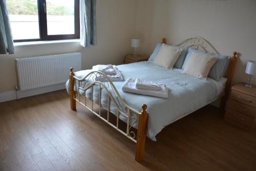 um quarto com uma cama com duas toalhas em Copper Coast B&B em Bunmahon