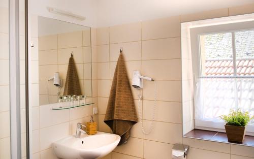 ein Bad mit einem Waschbecken und einem Spiegel in der Unterkunft Hotel Alt-Oberndorf in Oberndorf bei Salzburg