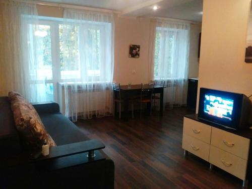 a living room with a couch and a tv and a table at Vivaldi Apartment in Dnipro