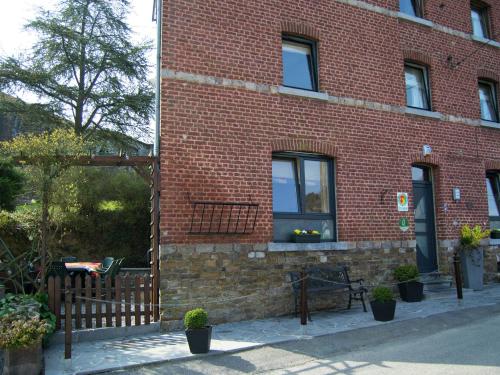 un edificio in mattoni con una recinzione di legno di fronte ad esso di Boutique Holiday Home in Durbuy with Garden a Verlaine