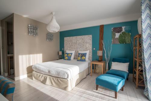 een slaapkamer met een bed en een blauwe muur bij Aux 5 Sens in Tillé