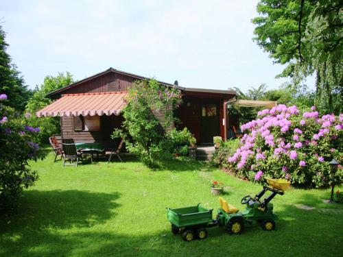 ミュンヒベルクにあるBeautiful holiday home with terraceの小さな家とおもちゃのトラクターのある庭園
