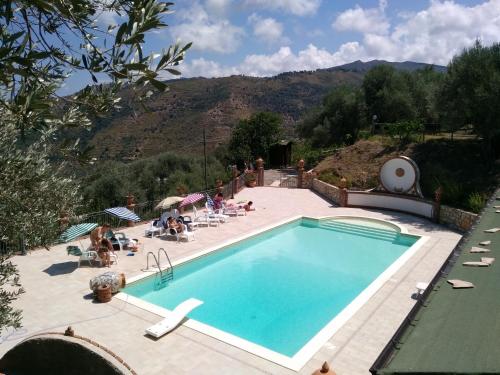 a large swimming pool with people sitting around it at L'Uliveto in Reitano