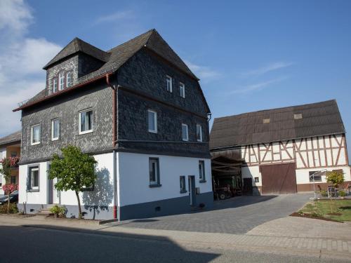 una gran casa en blanco y negro con un granero en Spacious holiday home between Mosel and Hunsr ck, en Blankenrath