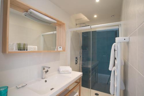 W łazience znajduje się umywalka i prysznic. w obiekcie Aux 5 Sens w mieście Tillé