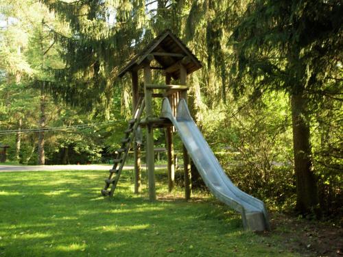 a playground with a slide in a park at Chalet in Reinskopf with Fireplace & Balcony in Schönecken