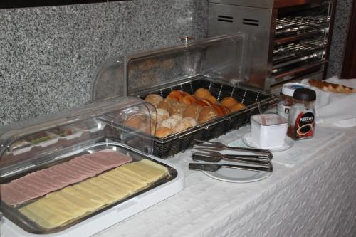 a table with a tray of food and a tray of bread at Hotel Quasar in Porto