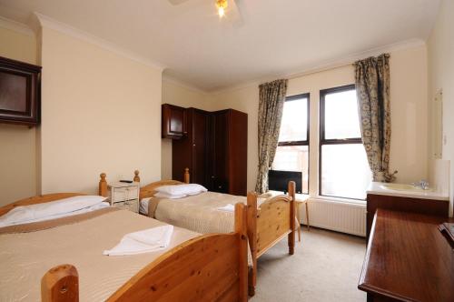 a bedroom with two beds and a window at The Rathmore in Cambridge