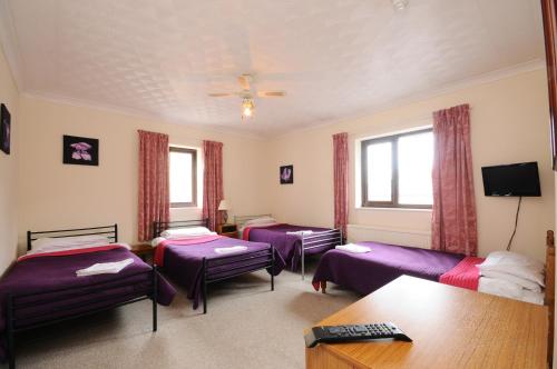 a room with three beds and a table at The Rathmore in Cambridge