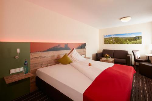 Hotel Gasthof Sonne في Fridingen an der Donau: غرفة فندقية بسرير كبير واريكة