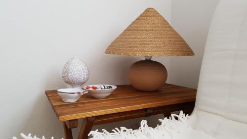 a table with a lamp and bowls on it at Villetta Cinquale Versilia in Cinquale