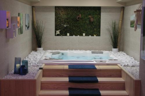 a bathroom with a jacuzzi tub in a room at Aux 5 Sens in Tillé