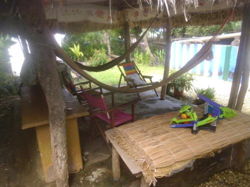 a room with a hammock and a table and chairs at Hostal Santa Clara in San Antero