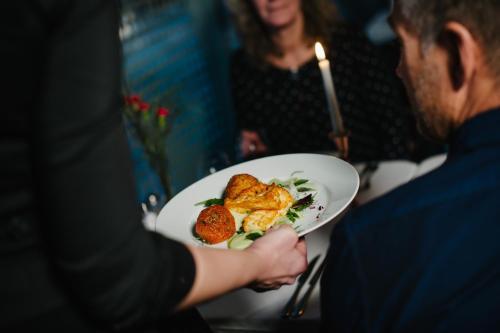 a man is holding a plate of food at Best Western Hotel Baltic in Sundsvall