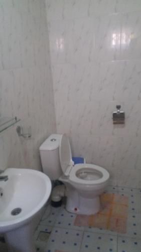 a bathroom with a white toilet and a sink at Adinkra City Hotel in Kasoa