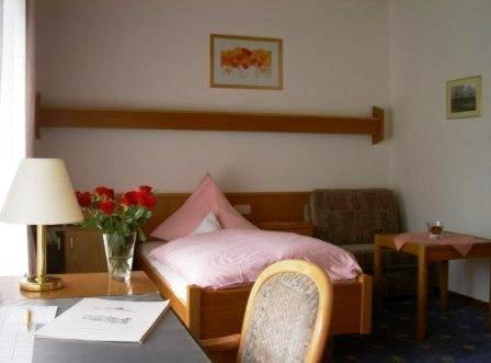 a bedroom with a bed and a table with a table sidx sidx sidx at Bengel's Hotel zur Krone in Mülheim-Kärlich