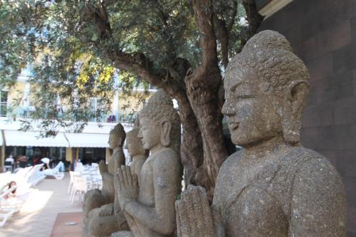 a group of statues standing next to a tree at Hotel la Palmera & Spa in Lloret de Mar