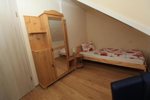 a small bedroom with a bed and a staircase at Waldhotel Albachmühle mit Albacher Stuben in Wasserliesch