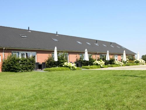 ein Gebäude mit einem Rasen davor in der Unterkunft Pretty Farmhouse in Haaksbergen near Forest in Haaksbergen