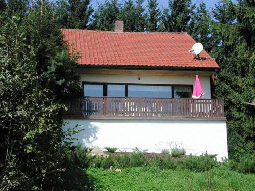 una casa con balcone con tetto rosso di Cozy Pet friendly Holiday Home in T nnesberg a Tännesberg