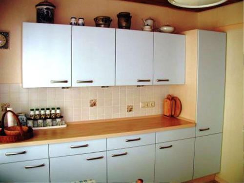 una cocina con armarios blancos y encimera de madera en Cozy Pet friendly Holiday Home in T nnesberg, en Tännesberg