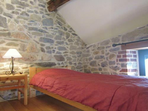 a bedroom with a stone wall with a bed at Alpine Getaway in Neustift in Treignes