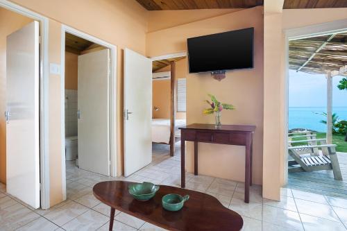 a living room with a television and a table at Luna Sea Inn in Bluefields
