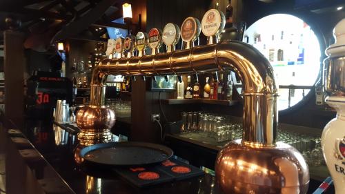 a bar with a counter with a copper bar istg at Hotel Peninsula Redpine in Mumbai