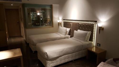 a hotel room with two beds and a mirror at Hotel Peninsula Redpine in Mumbai