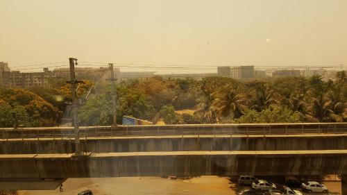 a bridge over a river with a city in the background at Hotel Peninsula Redpine in Mumbai