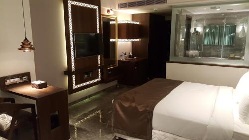 a bedroom with a bed and a television in it at Hotel Peninsula Redpine in Mumbai