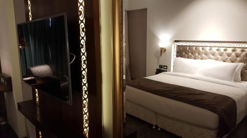 a bedroom with a large mirror next to a bed at Hotel Peninsula Redpine in Mumbai