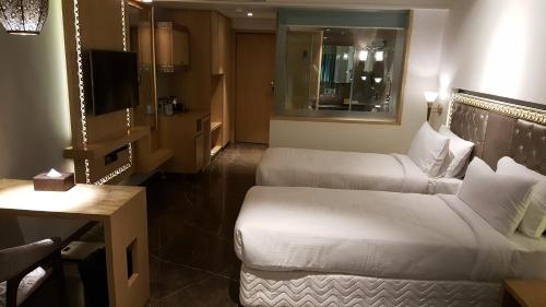 a hotel room with two beds and a couch at Hotel Peninsula Redpine in Mumbai