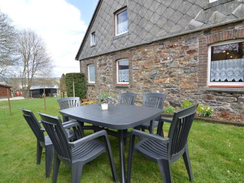 a black table and chairs in front of a building at Charming cottage near famous Francorchamps in Francorchamps