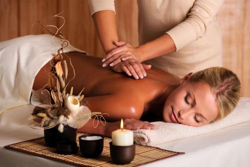 a woman getting a massage in a spa tub at Gościniec Darłowo & Spa in Darłowo