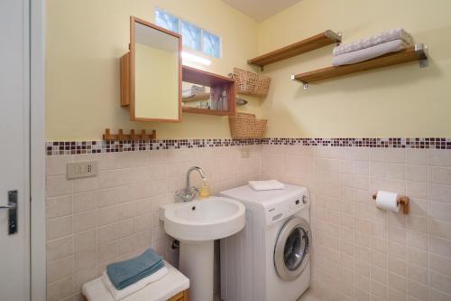 a bathroom with a washing machine and a sink at Casa Bosio in Bosio