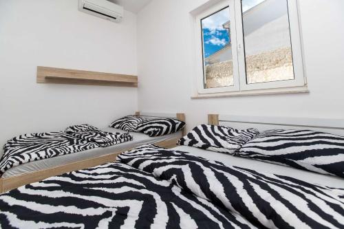 twee bedden in een kamer met een raam bij Lux Apartment in Jadranovo