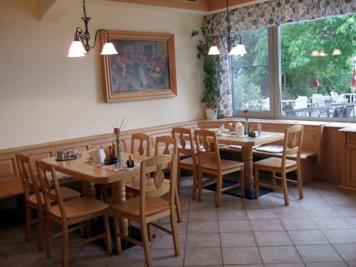 une salle à manger avec des tables et des chaises ainsi qu'une fenêtre dans l'établissement Gasthof-Pension Wein, à Breitenbrunn am Neusiedler See