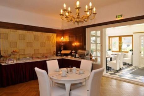 a dining room with a white table and white chairs at Hotel Schmidt in Hamburg